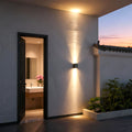 LED outdoor wall wash lights illuminating textured stone wall outdoors.