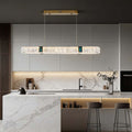 Oval crystal chandelier with a gold frame, illuminating a modern kitchen island.