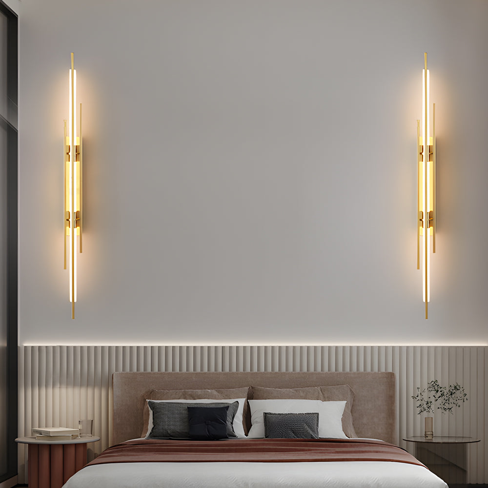 Pair of vertical tube wall sconces mounted symmetrically above bed.