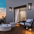 Contemporary patio space with cage-style wall sconces mounted on exterior walls at twilight