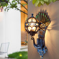 Peacock wall light illuminated on modern exterior wall at night.