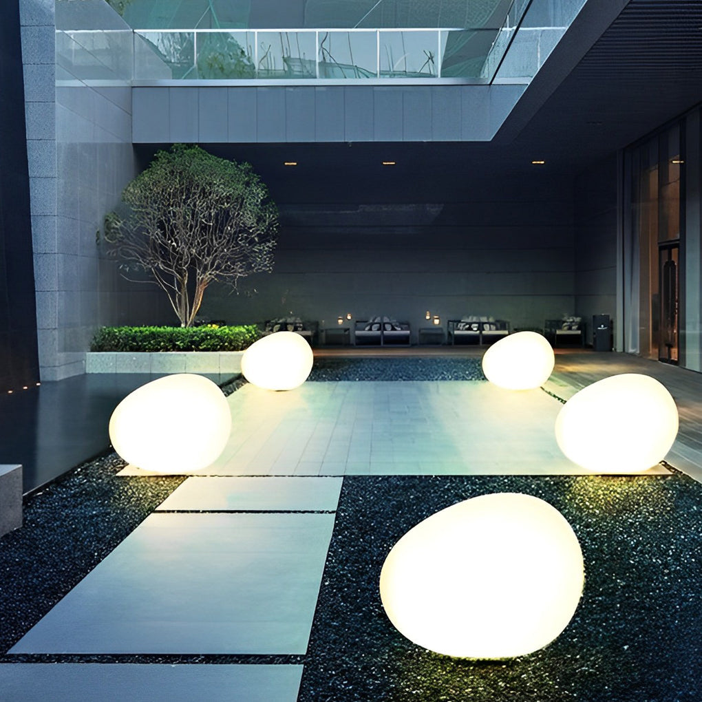 Pebble lights creating cozy atmosphere beside pool and seating area.