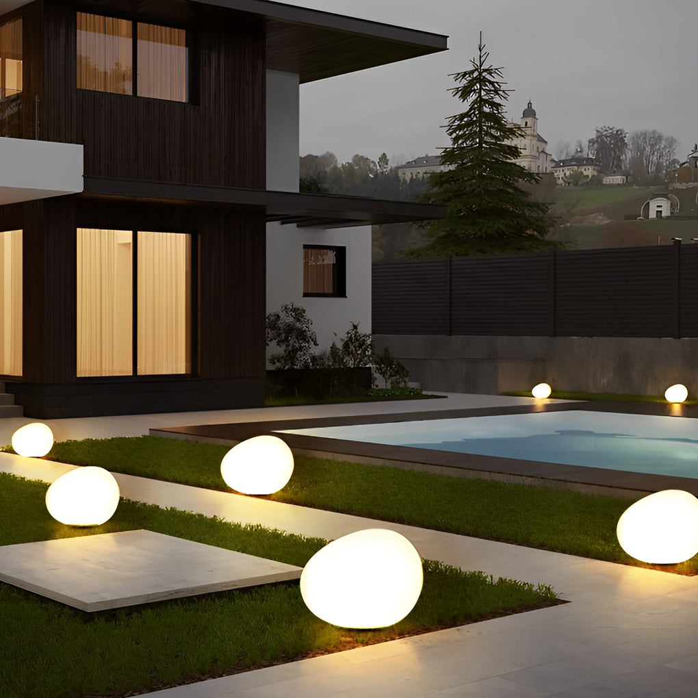 Pebble lights illuminating garden steps with soft light.