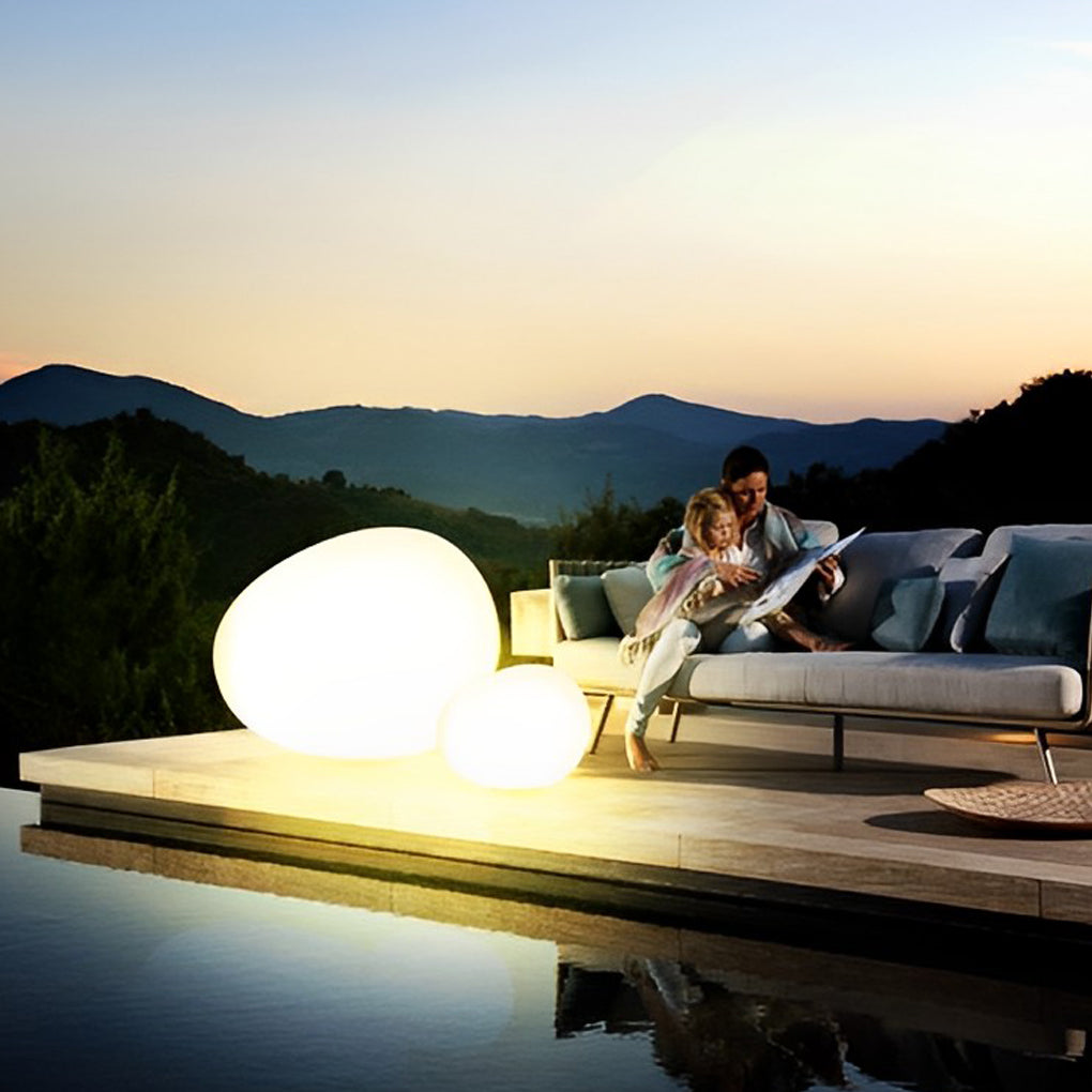 Pebble lights illuminating outdoor space with sunset background.