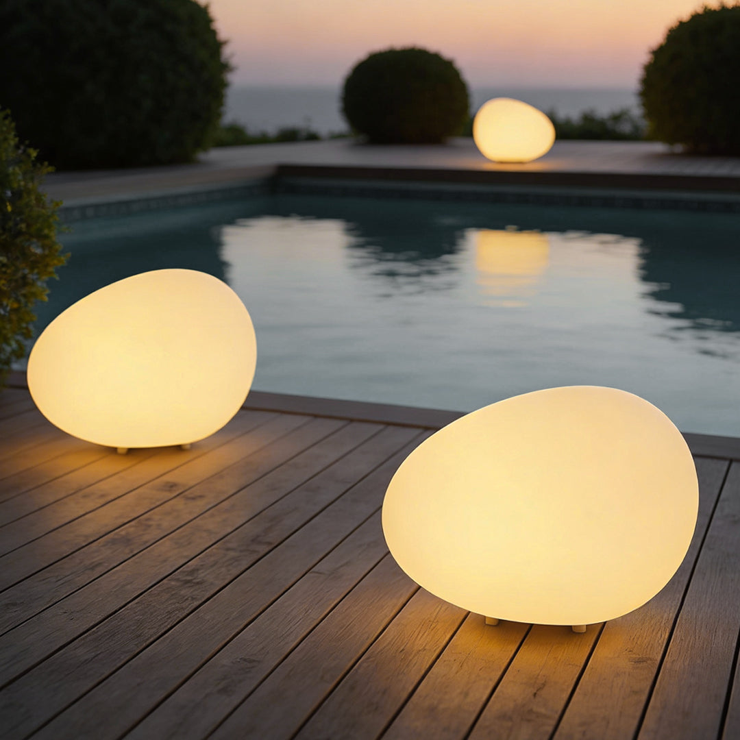 Pebble lights casting warm light beside modern pool area.