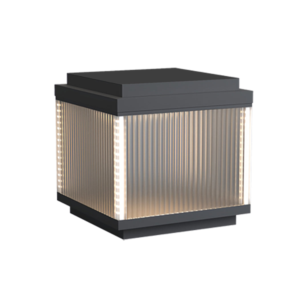 Square pillar lighting outdoor fixture with warm vertical light diffusion through ribbed glass.