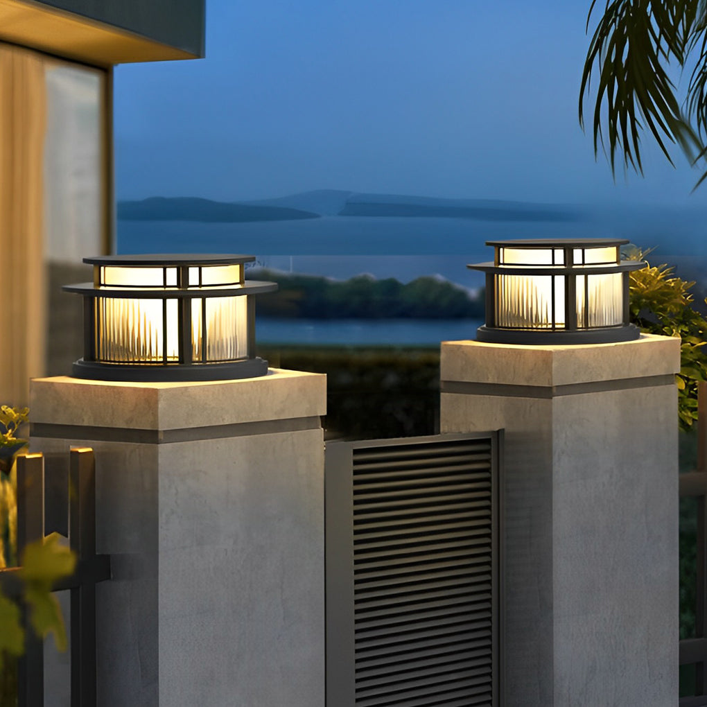 Outdoor pillar solar lights installed on gate posts with warm glow.