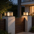 Pillar solar lights installed on modern entrance posts with warm outdoor gate lighting at night.
