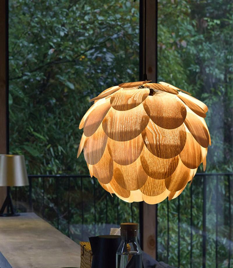 Pinecone pendant light with a natural wood design, hanging in a minimalist interior.