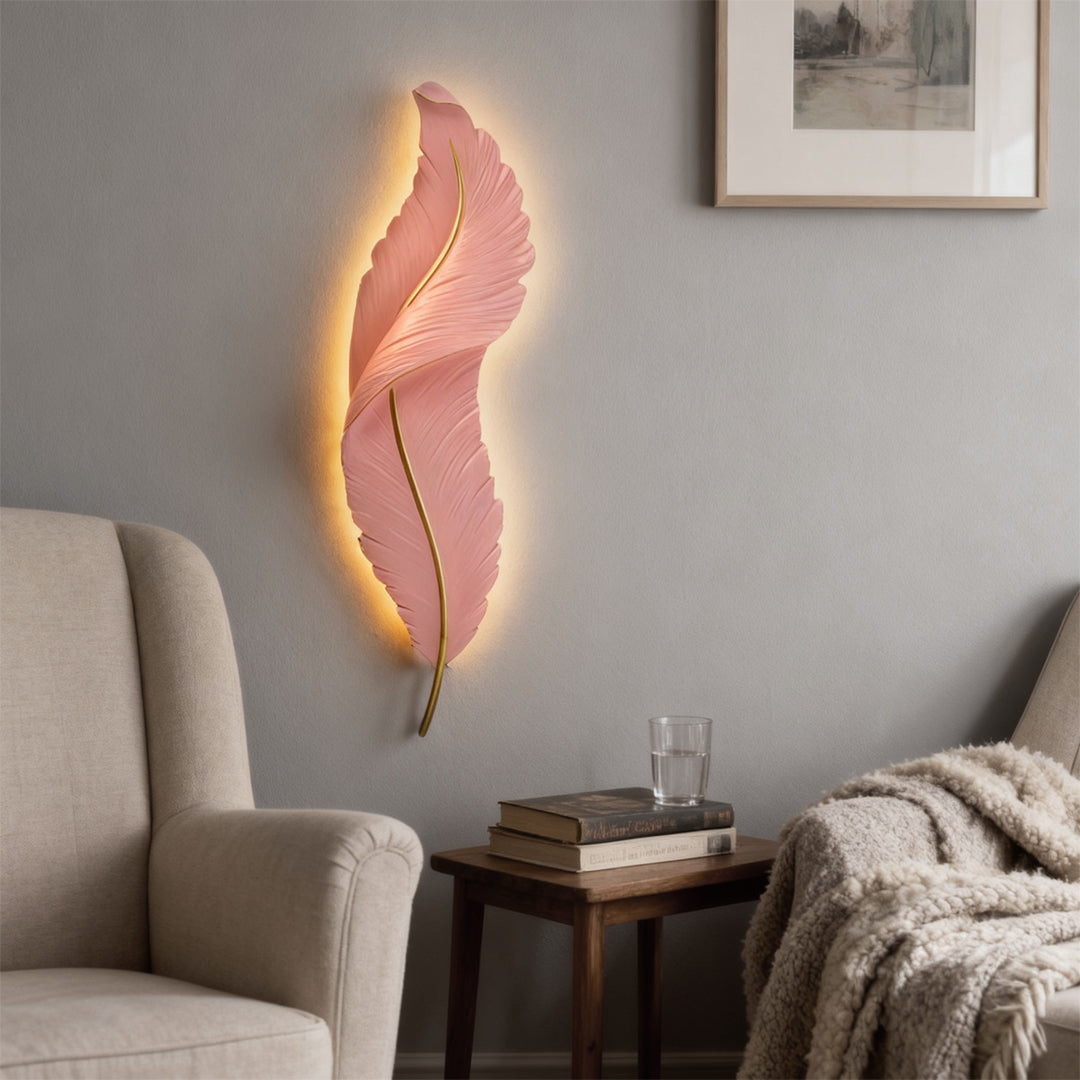 Pink feather wall light creating soft ambient lighting in cozy reading corner.