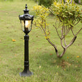 Poles for yard lights standing in a lush garden, providing classic outdoor illumination.