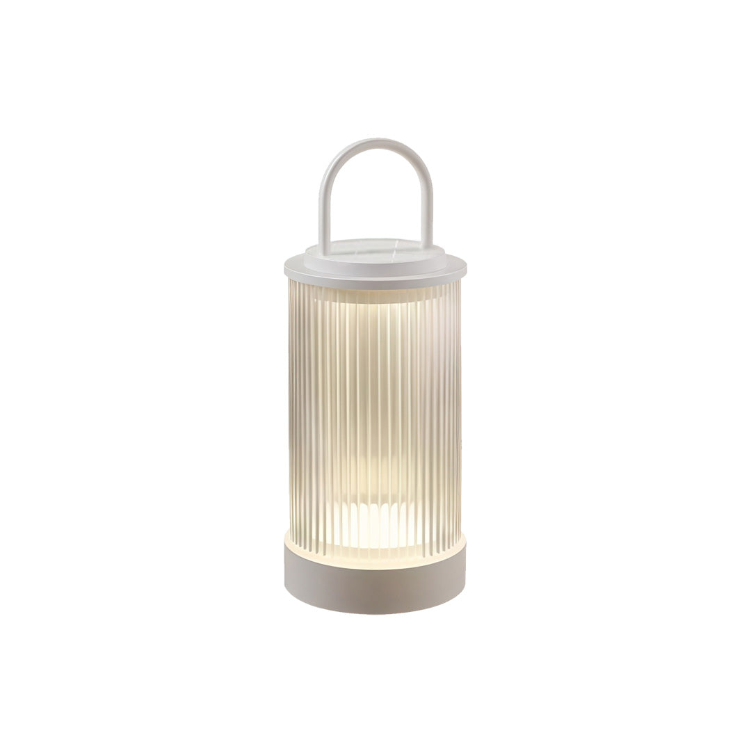 Portable lantern placed beside wood slat fence providing cozy garden ambiance during dusk.