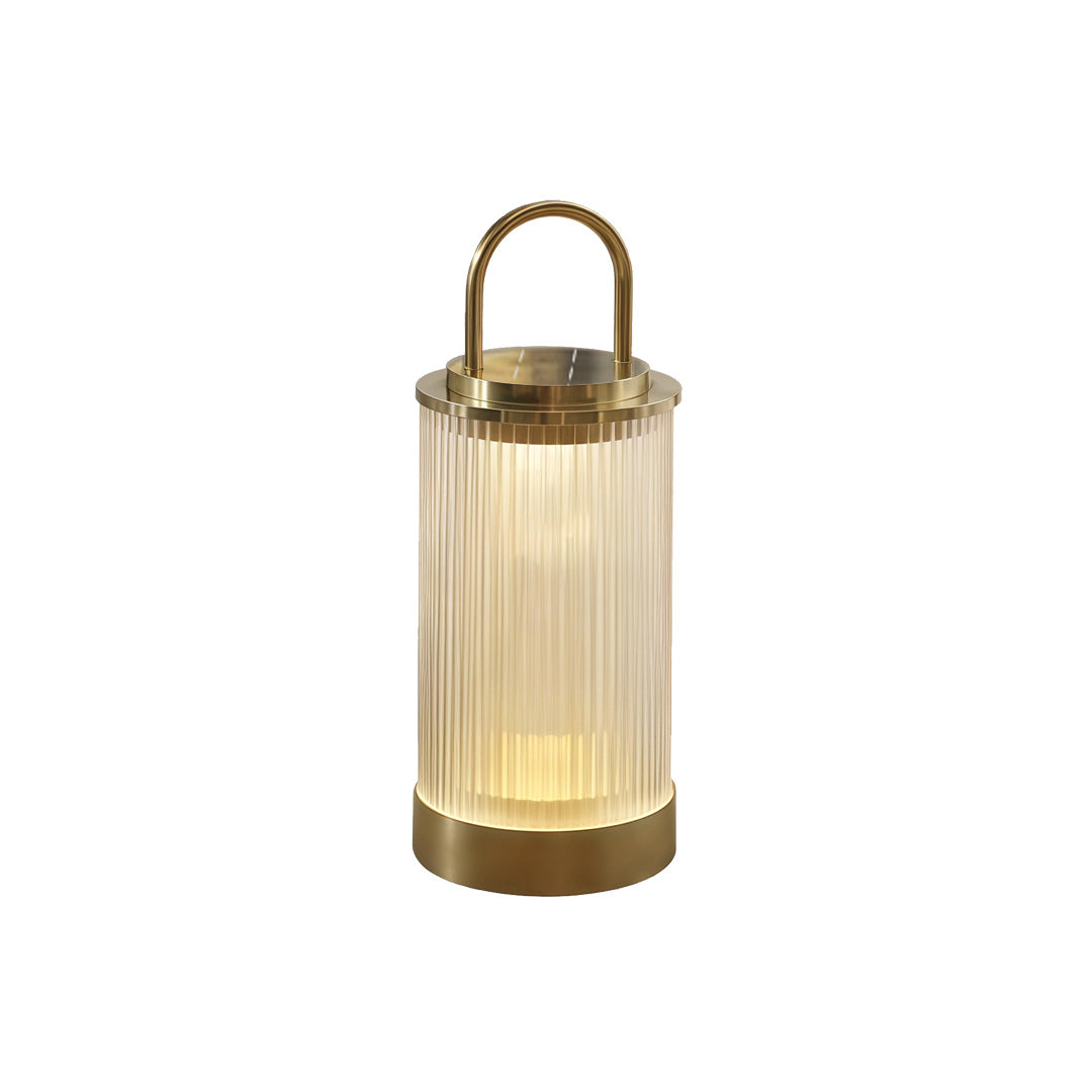 Portable lantern glowing next to modern landscaping and pathway for soft nighttime illumination.