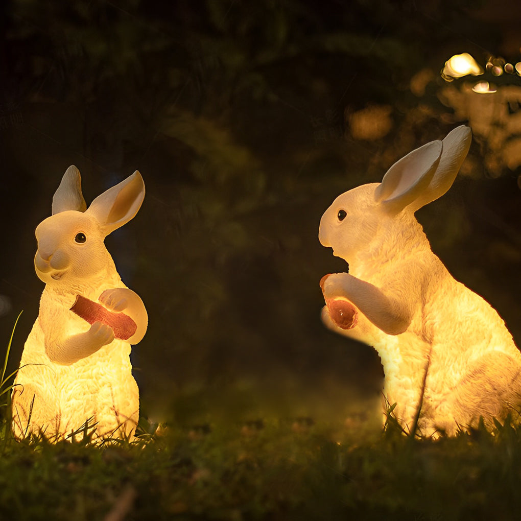Close-up of a rabbit garden light with a gentle glow, sitting on a lush green lawn.