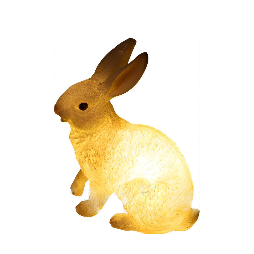 Rabbit garden light with a soft yellow light, standing alone against a white backdrop.