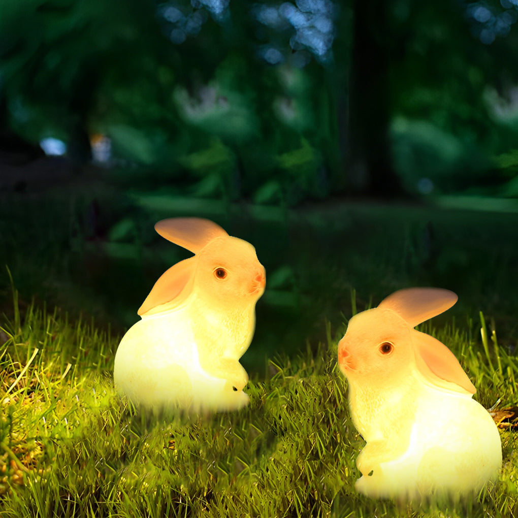 Rabbit garden light glowing warmly in a grassy area, creating a cozy outdoor ambiance.