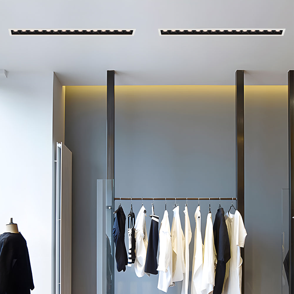 Recessed ceiling spot lights arranged in parallel lines in a modern corridor.