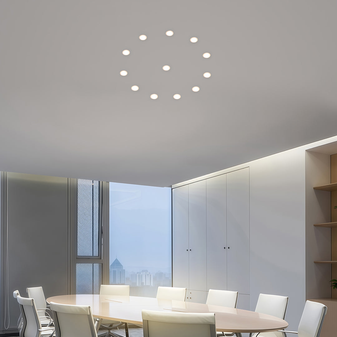 Circular arrangement of recessed ceiling spotlights creating decorative lighting pattern on gray ceiling.