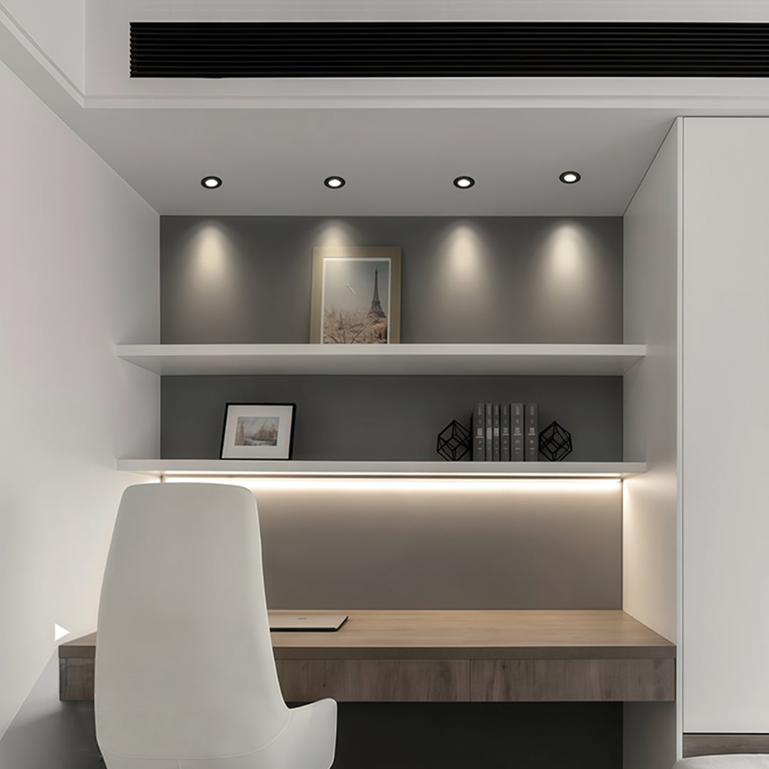 Recessed ceiling spotlights illuminating contemporary display shelving with focused accent lighting.