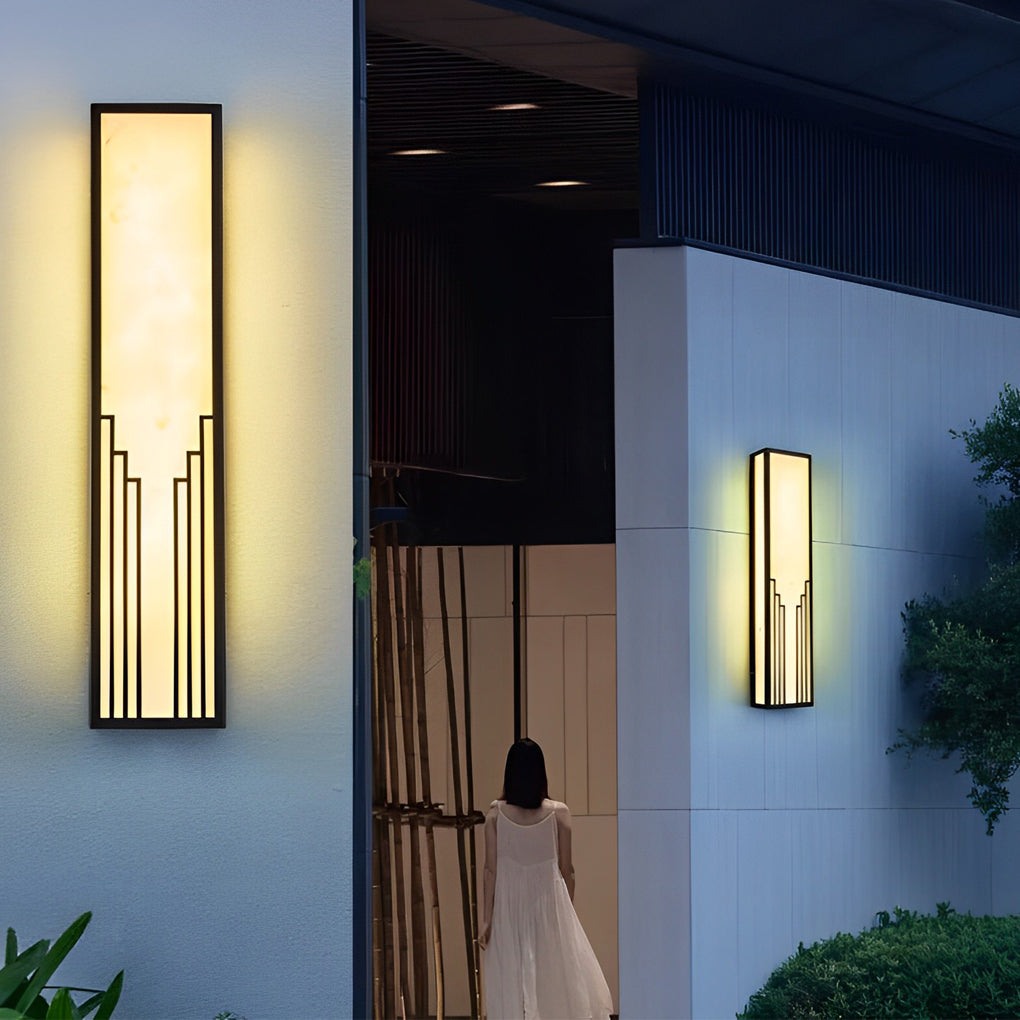 Rectangular exterior wall sconce with a modern design, illuminating a stylish courtyard.