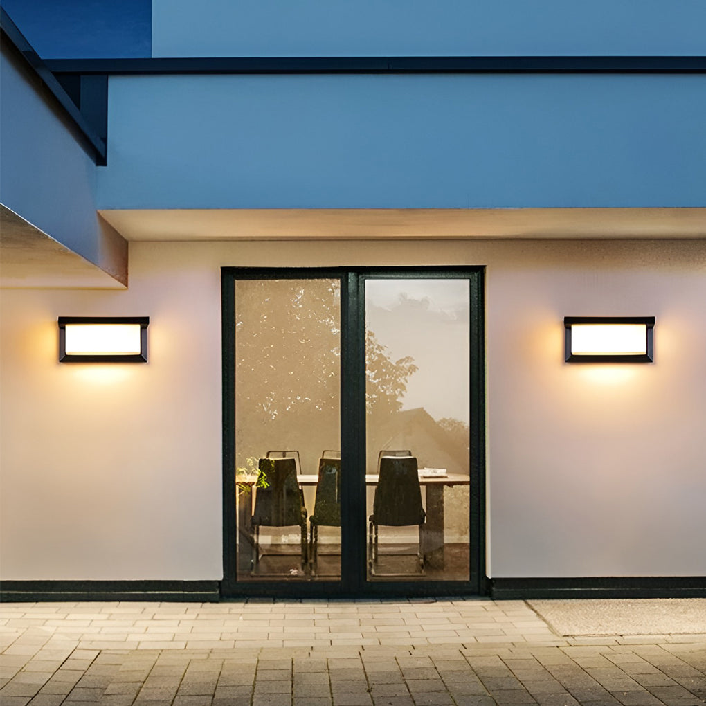 Rectangular outdoor wall lights illuminating a minimalist outdoor seating area with focused glow.