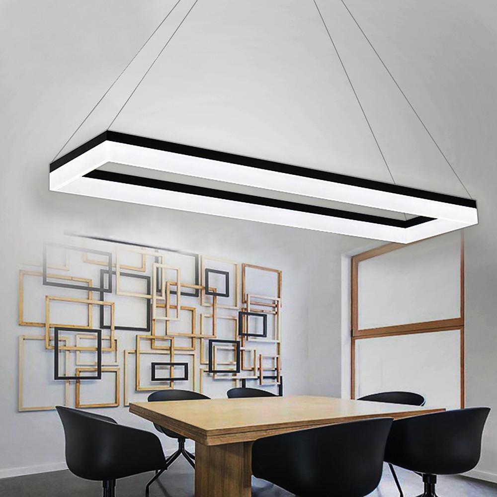 Modern rectangular pendant light suspended above dining-style meeting table.