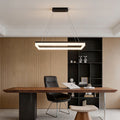 Rectangular pendant light installed above executive desk in modern office interior.