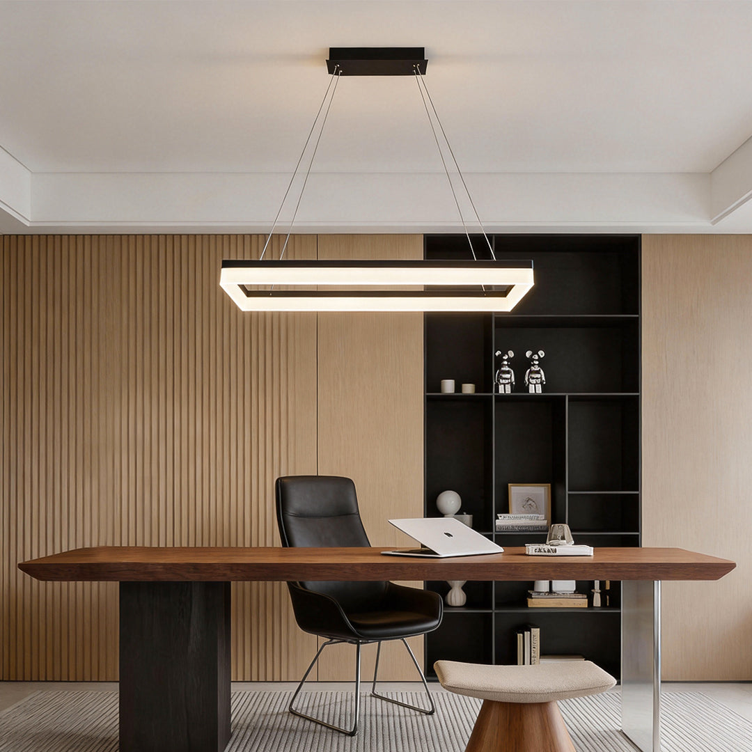 Rectangular pendant light installed above executive desk in modern office interior.