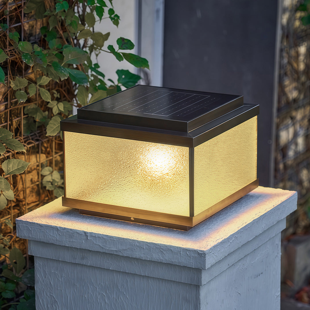 Garden pillar lights on granite posts framing residential entrance with red brick home backdrop.