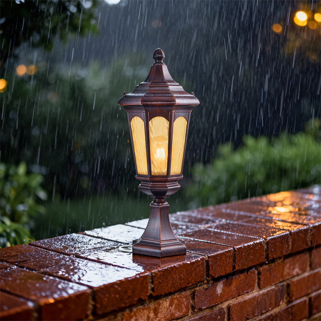 residential pillar light casting golden glow on brick wall in rainy evening with lush green surroundings