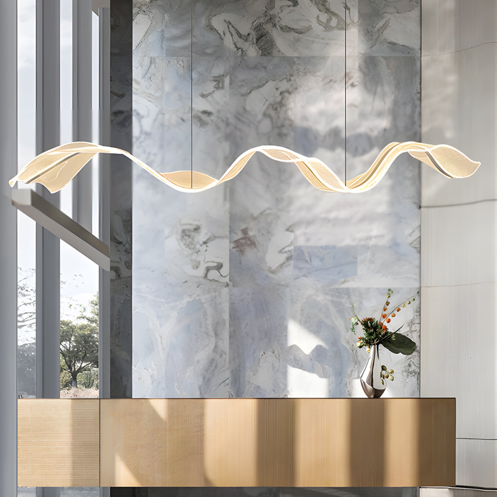 Ribbon pendant light with a golden wave design, enhancing a modern interior with soft light.