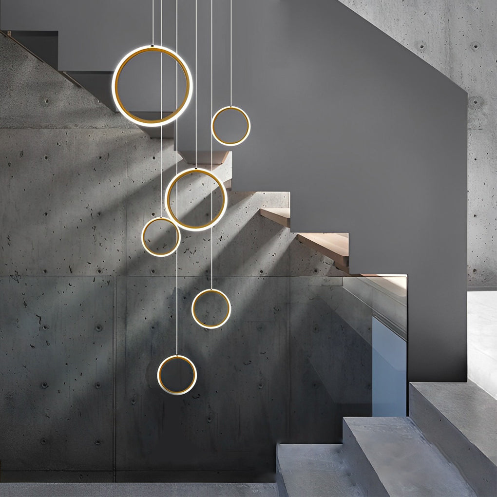 Ring staircase pendant light creating a warm ambiance in a modern staircase with concrete walls.