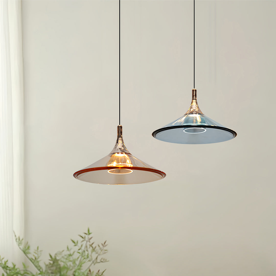 Rise and fall pendant lights with amber glass illuminating wall-mounted planter in modern space