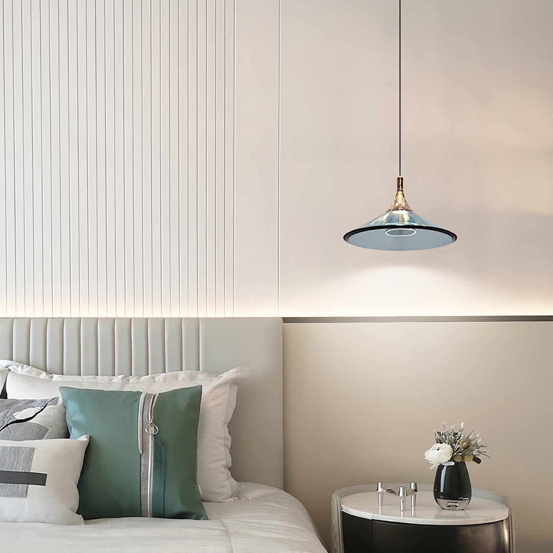 Rise and fall pendant lights with blue-tinted glass creating ambient glow in neutral bedroom setting