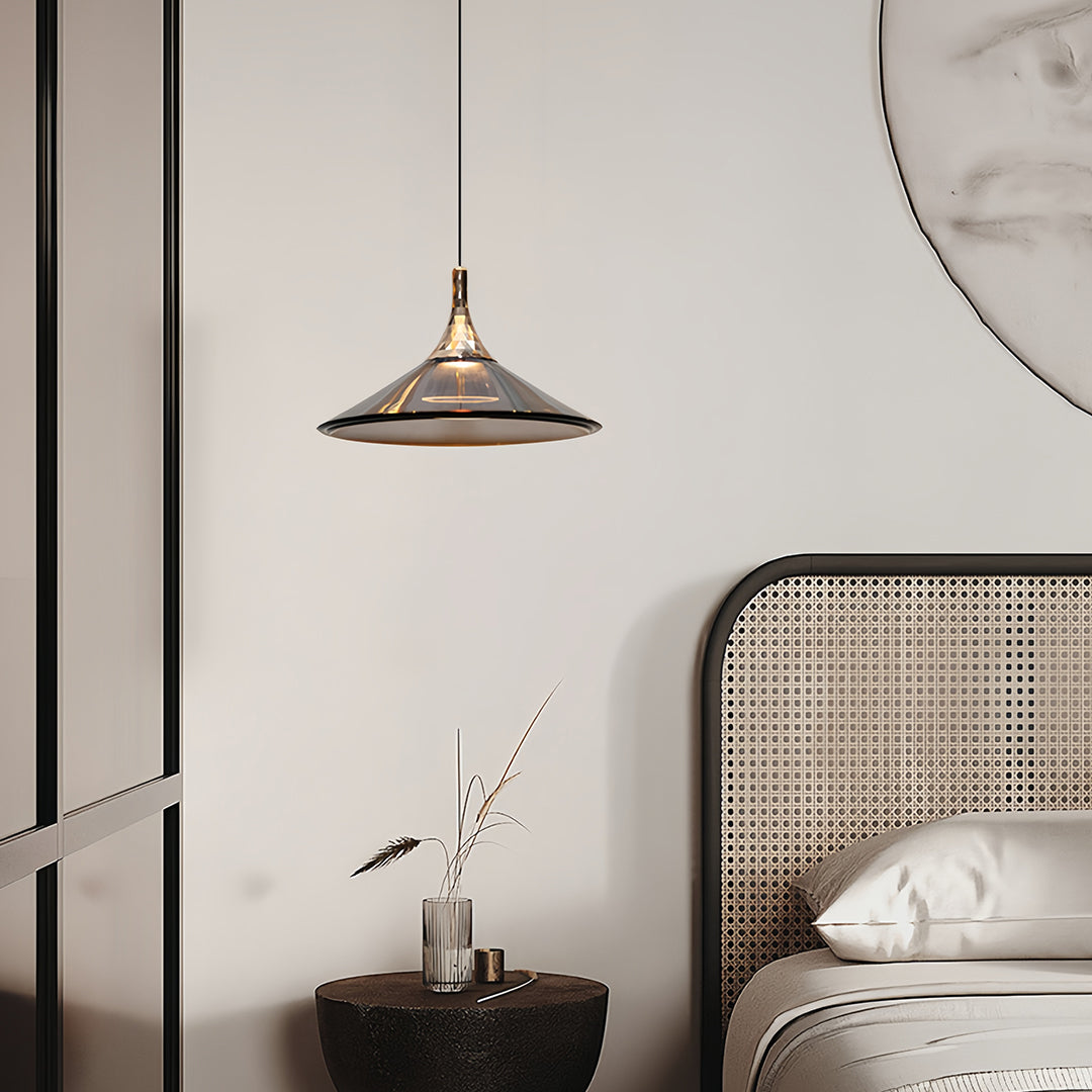 Rise and fall pendant lights with striped copper shade beside circular mirror in contemporary setting