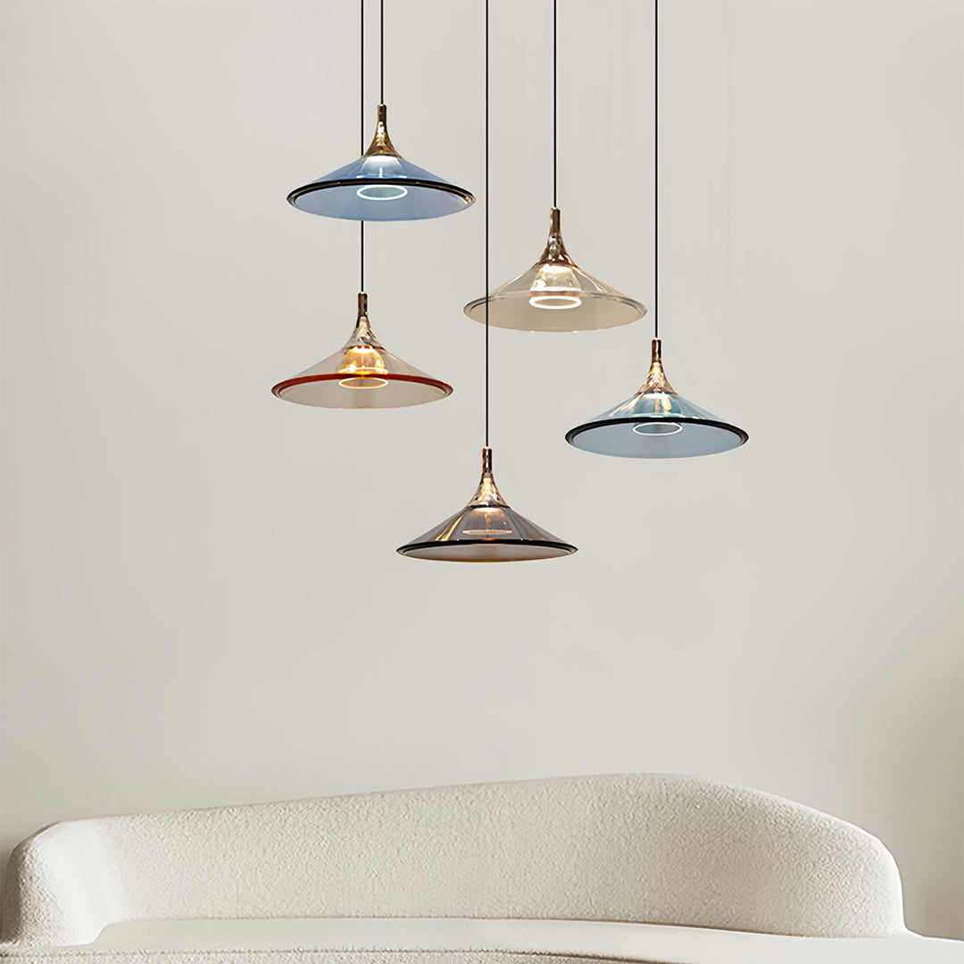 Trio of rise and fall pendant lights in mixed finishes clustered above modern dining table
