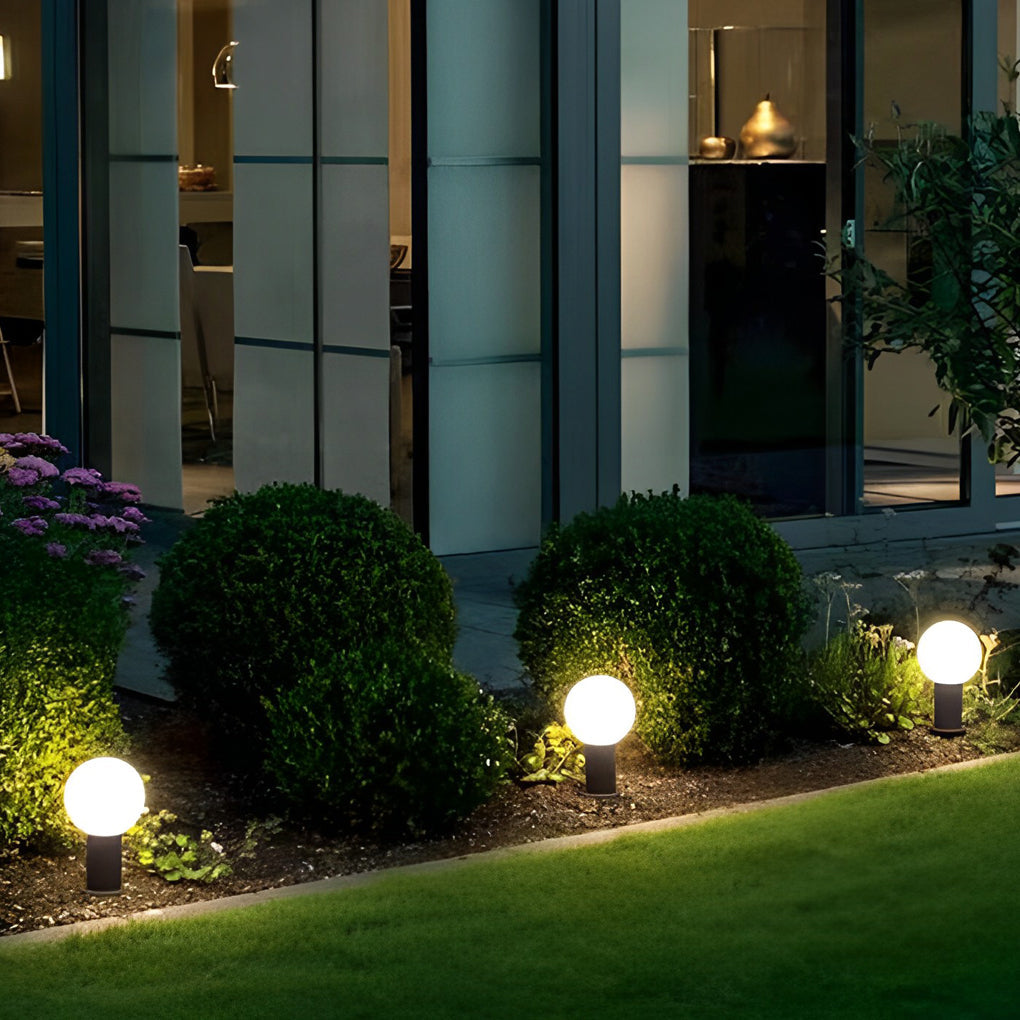 Round bollard lights with a black finish, providing ambient light near a lawn.
