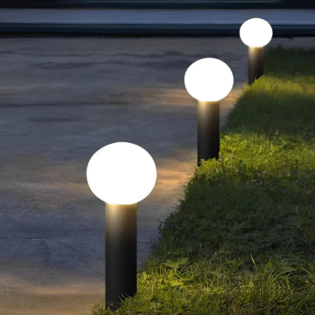Round bollard lights with a modern design, enhancing a landscaped garden.