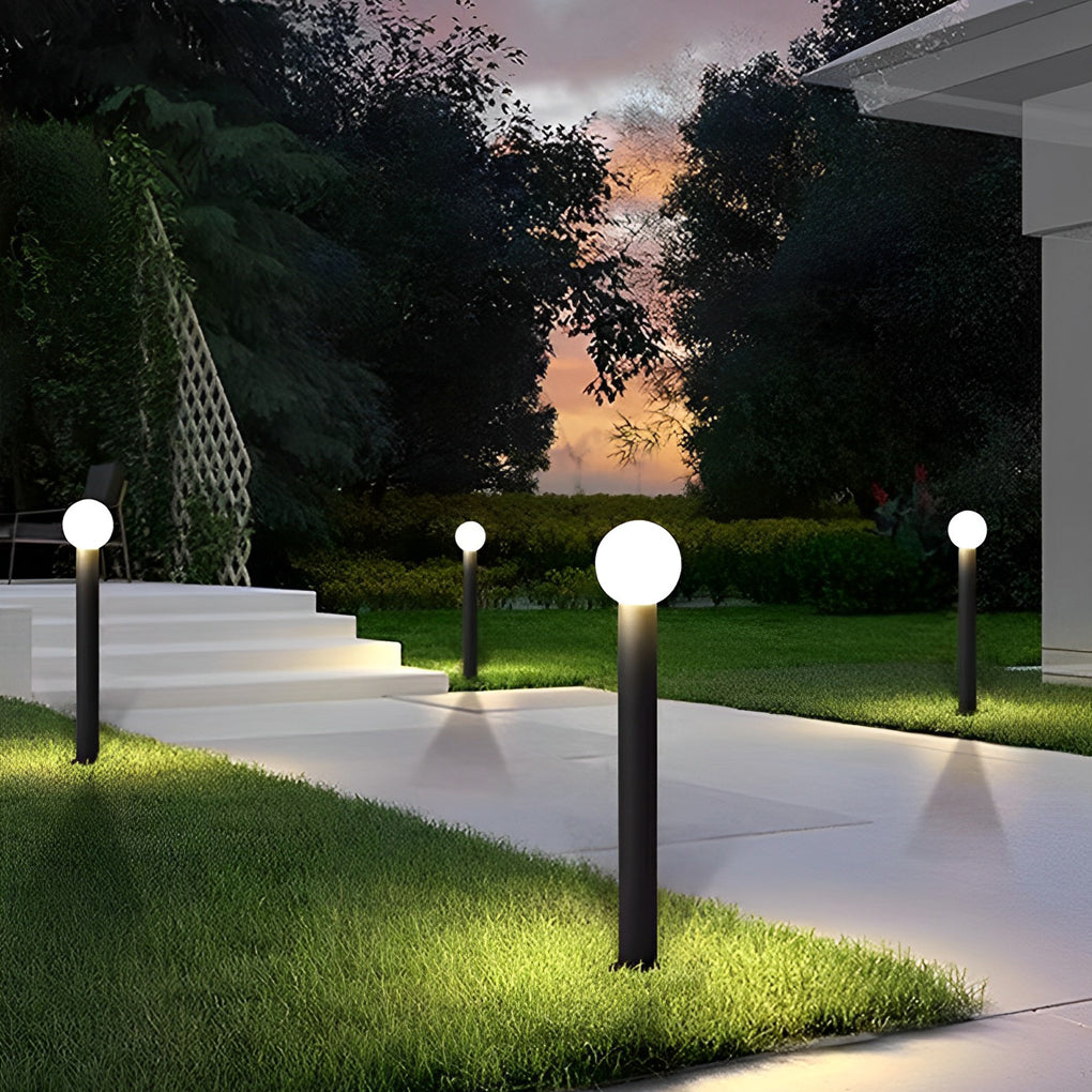 Round bollard lights with a sleek design, installed along a garden walkway.