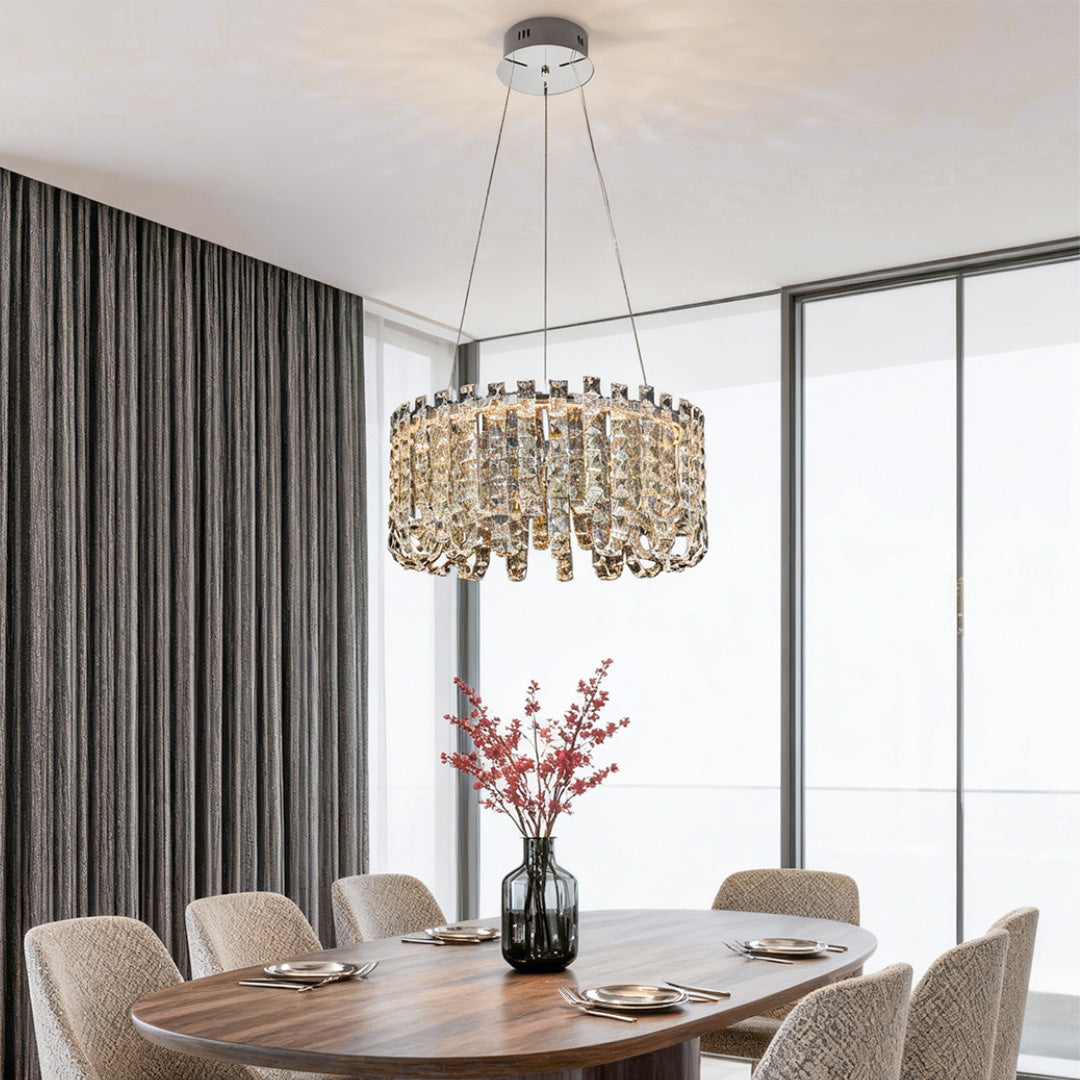 Dining room with round crystal chandelier modern above marble dining table.