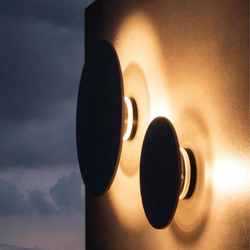 Round exterior wall lights with a minimalist design, mounted on a modern wall.