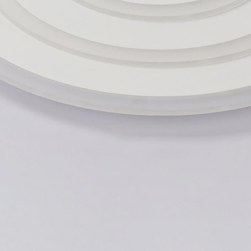 Round flush mount ceiling light providing ambient lighting in a contemporary living room.