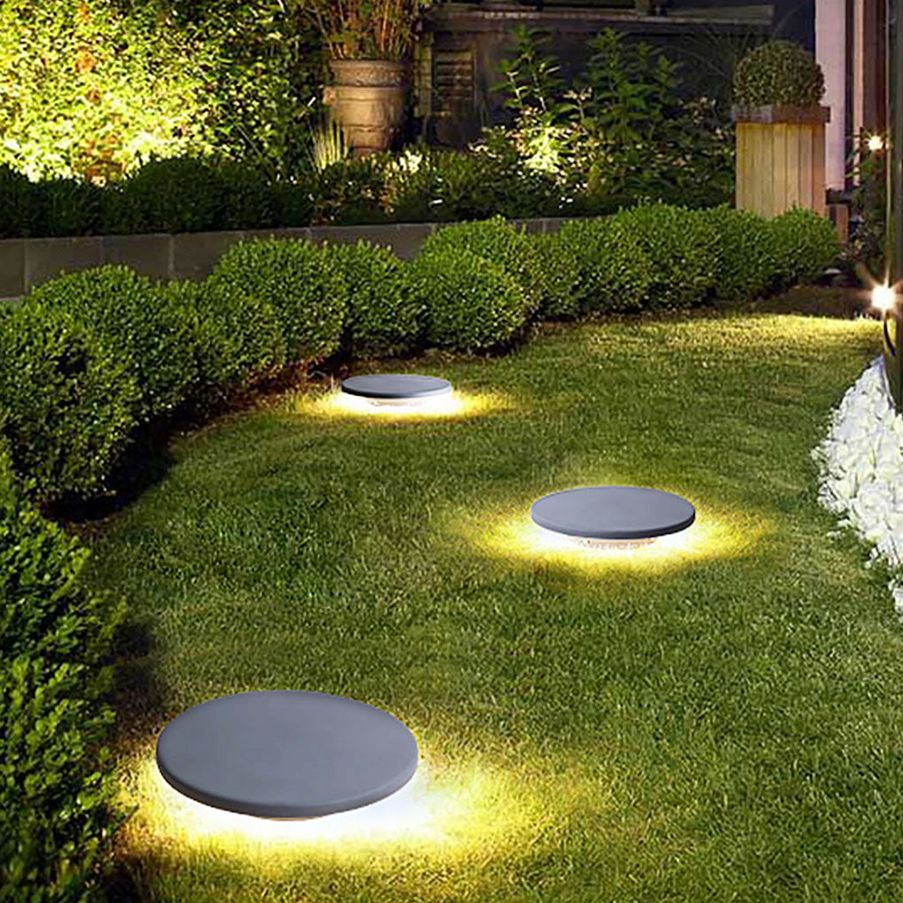 Round lawn light highlighting garden borders with warm ground lighting