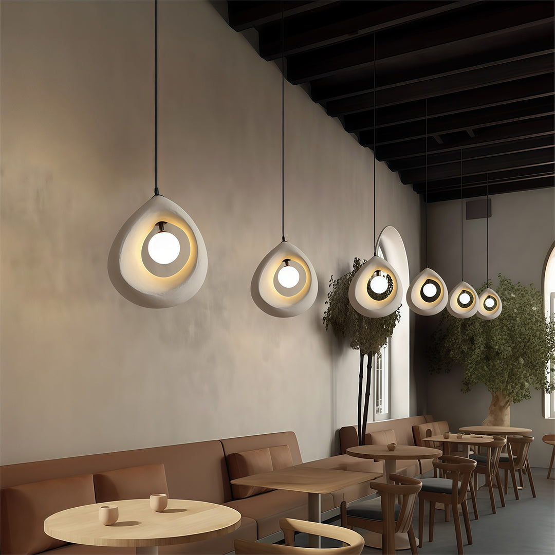 Row of statement pendant light creating warm atmosphere in a modern dining or bar space.