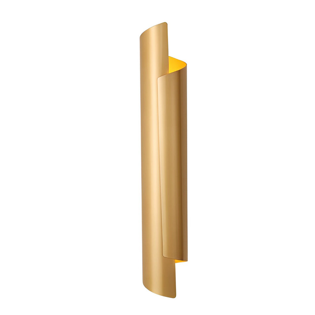Scroll wall sconce in gold, mounted on a white wall, complementing a green velvet armchair.