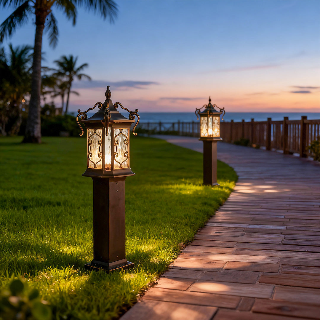 Bronze landscape post lights lining seaside path, creating elegant evening illumination.