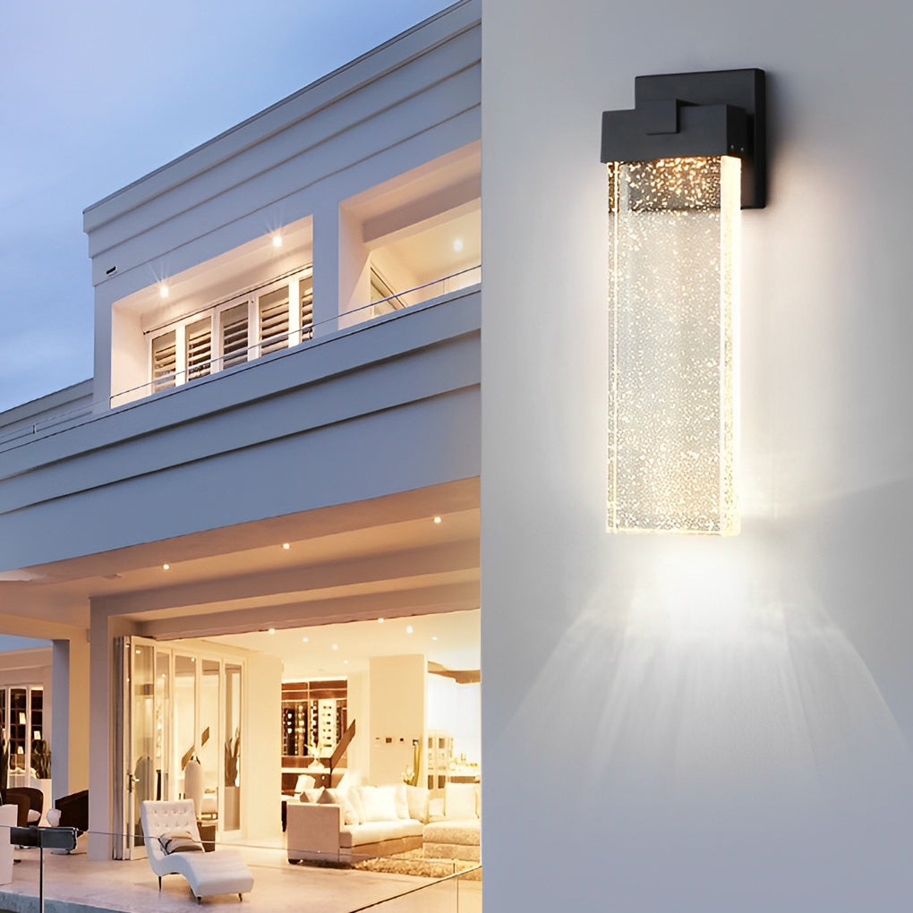 Seeded glass outdoor wall lighting installed on a modern house, casting ambient light.