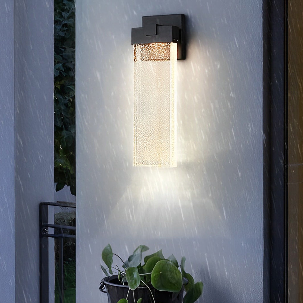 Seeded glass outdoor wall lighting mounted on a white wall, showcasing its modern design.