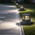 Short bollard light illuminating a modern garden pathway with warm ambient glow.