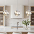 Elegant silver melt led pendant light trio over a modern marble kitchen island in bright room.